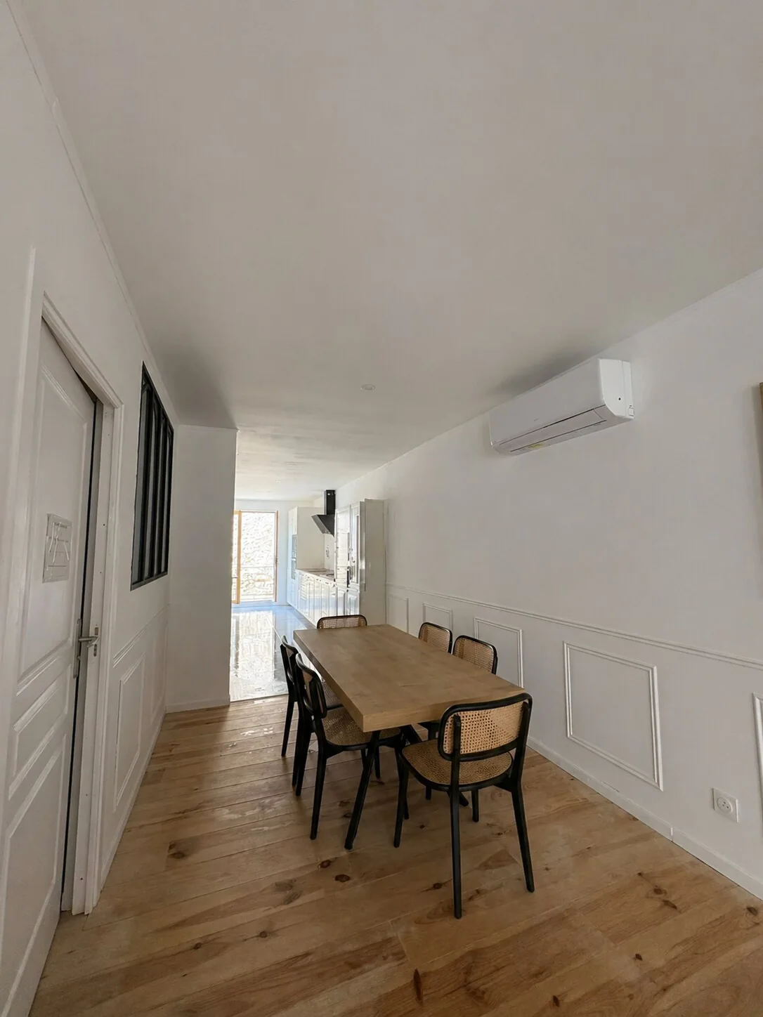 Salle à manger avec grande table en bois et six chaises