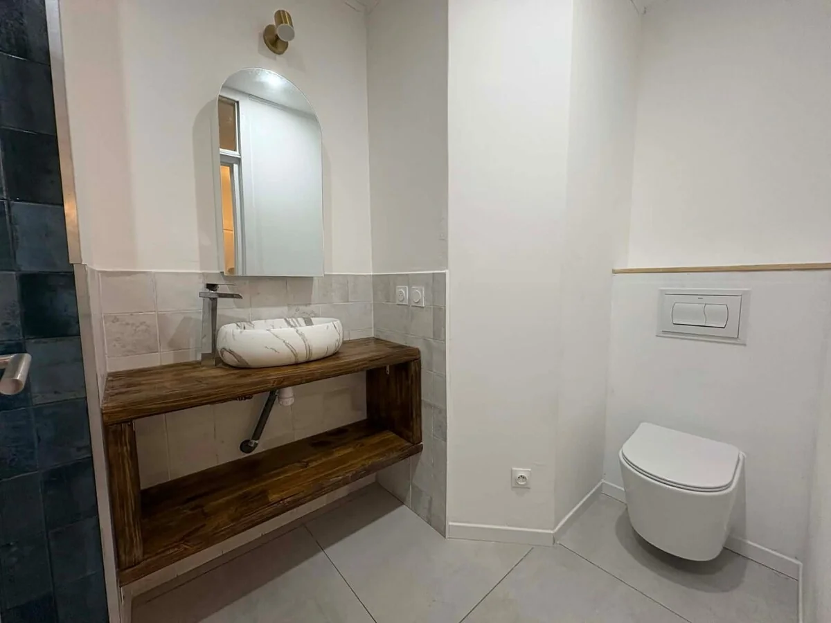 Salle d’eau avec vasque en pierre et finitions en bois